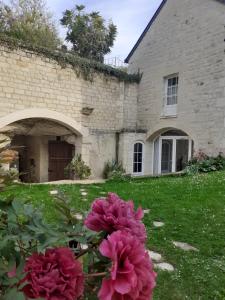 een huis met roze bloemen in de tuin bij Esprit Troglo in Beaumont-en-Véron