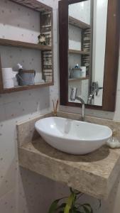 a sink in a bathroom with a mirror at Casa Inteira em Jurerê In e vista panorâmica in Florianópolis