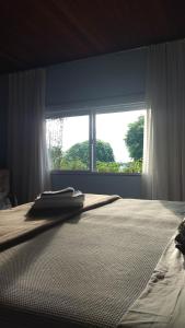 a bedroom with a bed with a large window at Casa Inteira em Jurerê In e vista panorâmica in Florianópolis