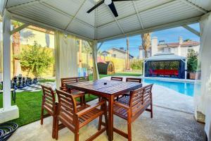 a wooden table and chairs under a pavilion at Buddha Play Modern with Pool & Spa Sauna Near Vegas strip in Las Vegas