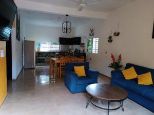 a living room with two blue couches and a table at casa flores in Bacalar