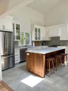 a kitchen with white cabinets and a large island with stools at Recently Renovated, Inviting Home in Quiet Location in East Hampton