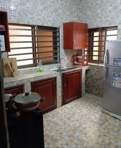 a kitchen with a sink and a refrigerator at Magnifique Maison de ville Bord de mer Cotonou Fidrjossè in Cotonou