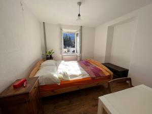 a bedroom with a large bed with a window at Sunshine House in Olivone