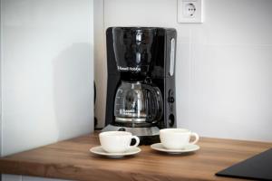 two cups on a counter with a coffee maker at Charming House Nino with a fenced yard in Krmed +49 photos
