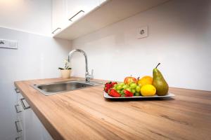 a plate of fruit on a counter in a kitchen at Charming House Nino with a fenced yard in Krmed