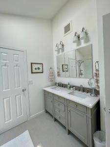 a white bathroom with a sink and a mirror at Recently Renovated, Inviting Home in Quiet Location in East Hampton