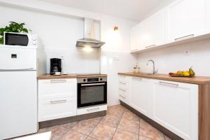 a kitchen with white cabinets and a sink at Charming House Nino with a fenced yard in Krmed