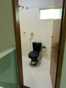 een badkamer met een zwart toilet en een raam bij Apto apoio Serra da Capivara in São Raimundo Nonato