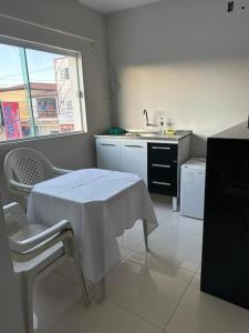 a white kitchen with a table and a sink at Apto apoio Serra da Capivara in São Raimundo Nonato