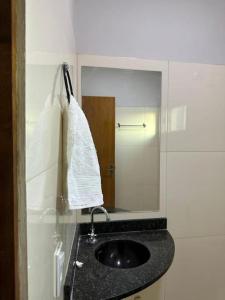 a bathroom with a sink and a mirror at Apto apoio Serra da Capivara in São Raimundo Nonato