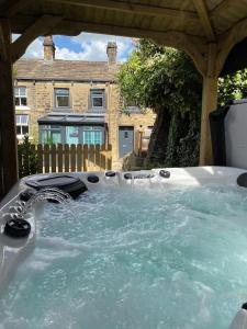 a hot tub in front of a house at Holmfirth Hideout in Holmfirth