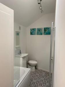 a white bathroom with a toilet and a sink at Holmfirth Hideout in Holmfirth