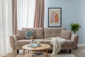 a living room with a couch and a table at Joy Garden Apartment - Free Private Parking - Wellness Jacuzzi SPA Extra Fee in Sinaia