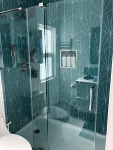 baño con ducha y puerta de cristal en Casa Pacifica en San Diego