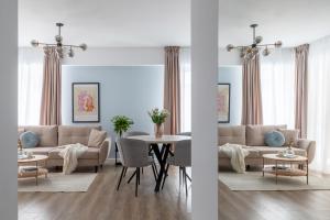 a living room with a couch and a table at Joy Garden Apartment - Free Private Parking - Wellness Jacuzzi SPA Extra Fee in Sinaia