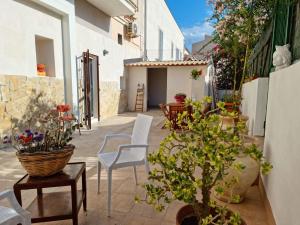a courtyard with chairs and a table and some plants at Sorelle di Riviera in Syracuse