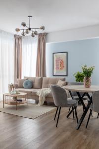 a living room with a couch and a table at Joy Garden Apartment - Free Private Parking - Wellness Jacuzzi SPA Extra Fee in Sinaia