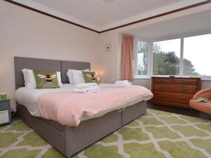 um quarto com uma cama grande e uma janela em 3 Bed in West Bay 78089 em Bridport