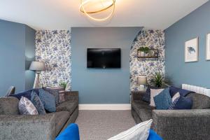 a living room with two couches and a flat screen tv at Modern Seafront 2 Bedroom Apartment - Brand New in Morecambe