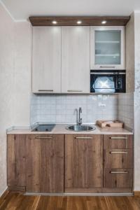 - une cuisine avec des placards en bois et un évier dans l'établissement Zlatibor.Lux.Stefanović 1, à Zlatibor