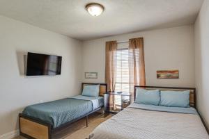 1 dormitorio con 2 camas, TV y ventana en Garland Vacation Rental about 16 Mi to Dallas!, en Garland
