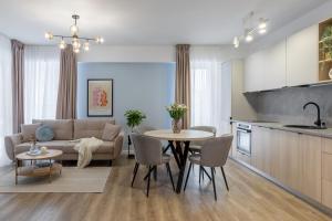 a living room and kitchen with a couch and a table at Joy Garden Apartment - Free Private Parking - Wellness Jacuzzi SPA Extra Fee in Sinaia