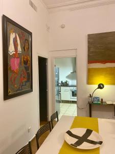 a dining room with a table and a painting on the wall at La Suite de la Cathédrale in Narbonne