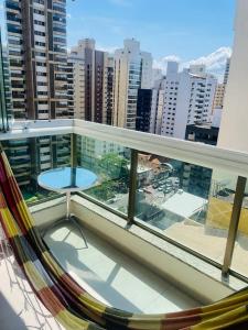 a balcony with a hammock and a view of a city at Flat na praia in Vila Velha