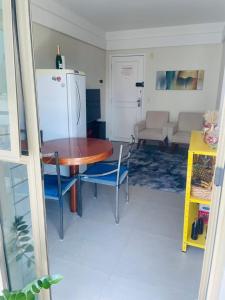 uma cozinha com uma mesa e cadeiras e um frigorífico em Flat na praia em Vila Velha