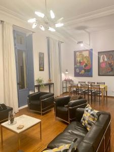 sala de estar con mesa y muebles de cuero negro en La Suite de la Cathédrale, en Narbona