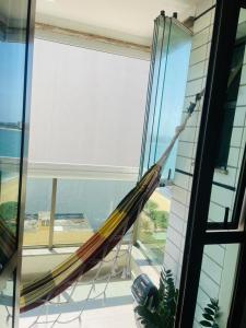 eine Hängematte auf einem Balkon in einem Haus in der Unterkunft Flat na praia in Vila Velha