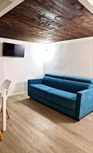 a blue couch in a room with a wooden ceiling at Casa con terrazza esclusiva vicino al mare Domus Neapolis Happy Holiday in Naples