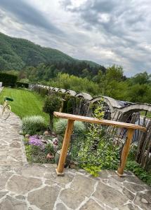 een houten bank in een tuin met een waterval bij Комплекс Антик in Troyan