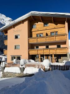 a building covered in snow in front of it at Pension DORFPLATZL Pitztal in Plangeross