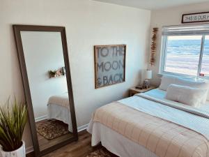 a bedroom with a bed and a mirror at Little Miss Magic in Gulf Shores