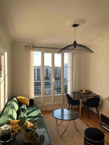 een woonkamer met een bank en een tafel bij Appartement Courbevoie in Courbevoie
