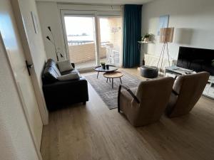 een woonkamer met een bank, stoelen en een tafel bij Appartement Strand Makkum in Makkum