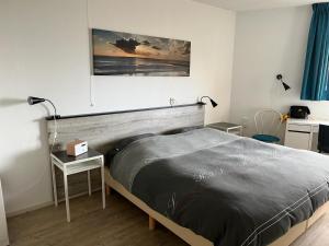 een slaapkamer met een bed en een tafel en een foto bij Appartement Strand Makkum in Makkum