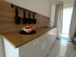 a bowl of fruit on a counter in a kitchen at Studio apartman Paola in Peroj