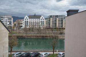 a group of cars parked in a parking lot next to a lake at Stadthotel Das Villach in Villach
