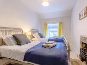 3 Bed in Great Hucklow 77715 في Hucklow: غرفة نوم بسريرين عليها مناشف