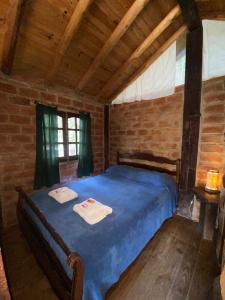 ein Schlafzimmer mit einem blauen Bett mit zwei Handtüchern darauf in der Unterkunft Cabañas Mangoré Rustica 25m2 La Granja Córdoba in La Granja