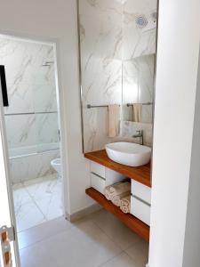 La salle de bains est pourvue d'un lavabo et d'une douche. dans l'établissement Pausa Soñada Junin BsAs -Dpto de 2 dormitorios con terraza y parrilla, à Junín