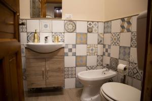 La salle de bains est pourvue de toilettes blanches et d'un lavabo. dans l'établissement CASA MAGIEM, à Palerme