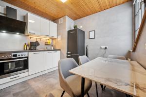 una cocina con armarios blancos y una mesa con sillas. en Wohnung Weitblick, en Neu-Anspach