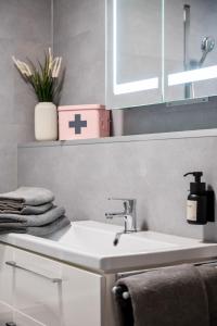 a bathroom with a white sink and a cross on the wall at Wohnung Weitblick in Neu-Anspach