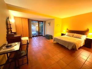 1 dormitorio con paredes amarillas, 1 cama y 1 mesa en Quinta Do Salgueiro B&B - Turismo Rural, en Freixo de Espada à Cinta