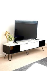 a flat screen tv on a black and white entertainment center at Modern Luxurious Apartment in Birmingham