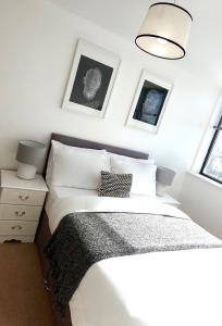 a bedroom with a white bed and two pictures on the wall at Modern Luxurious Apartment in Birmingham
